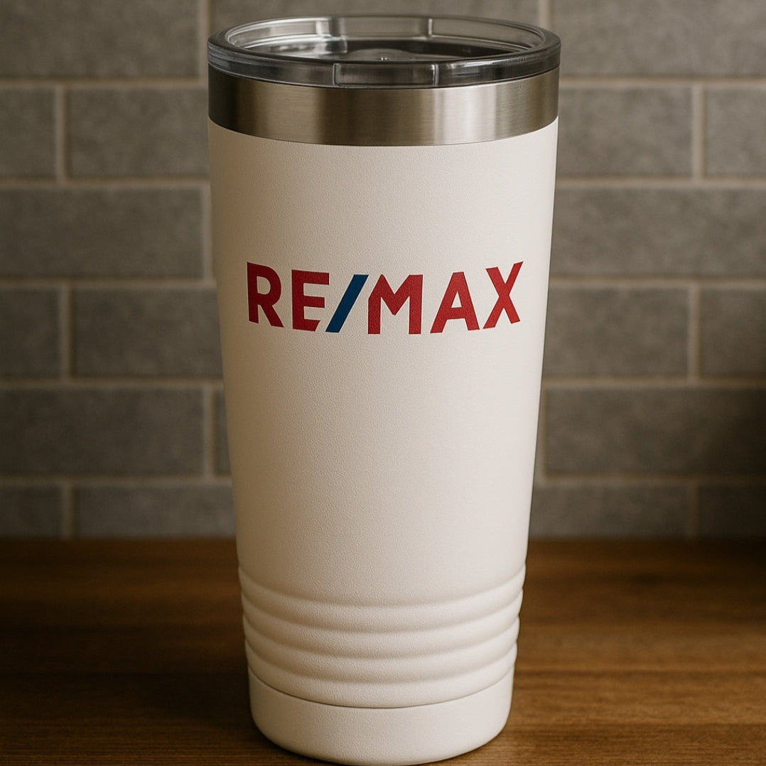 White tumbler with RE/MAX logo on a wooden surface and brick wall background