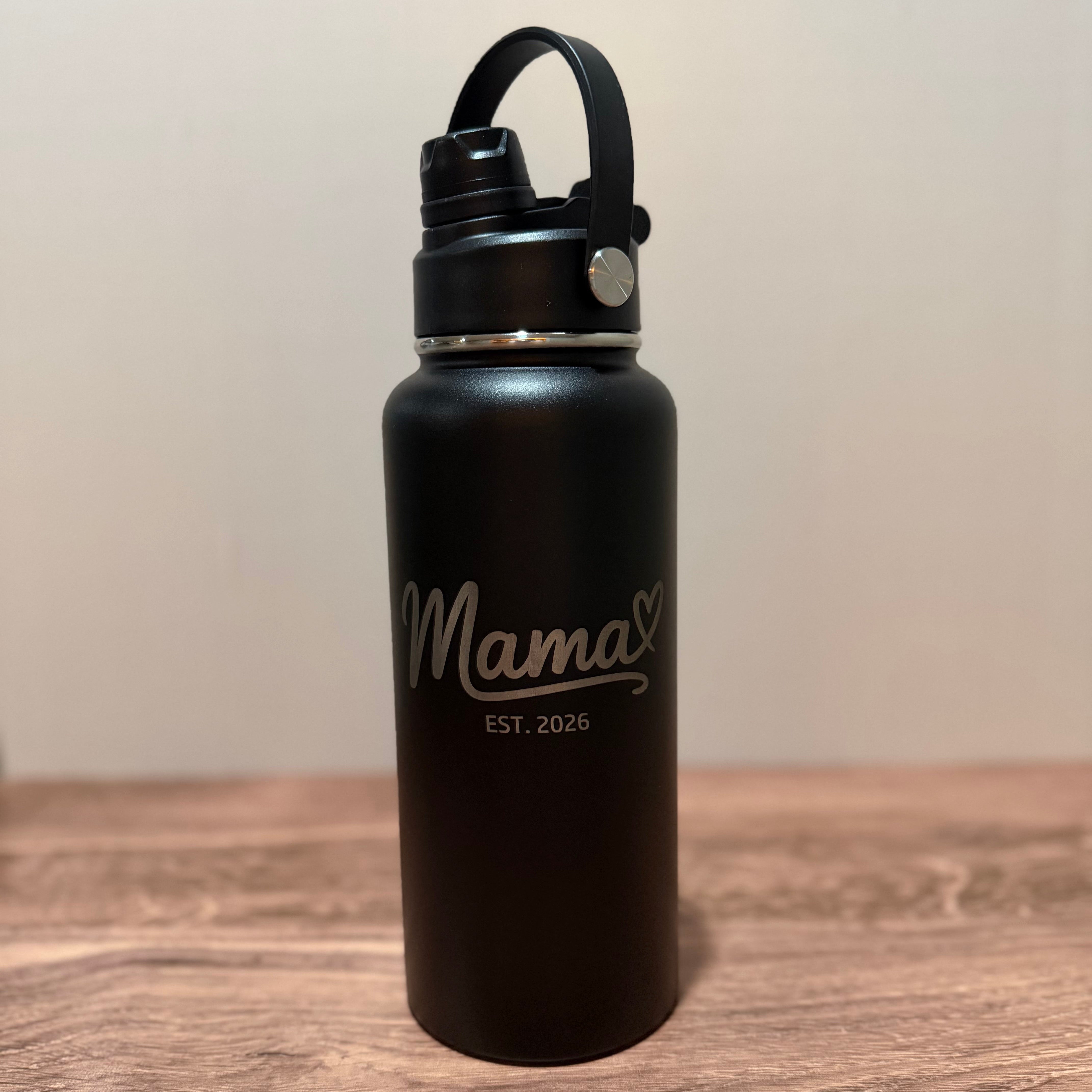 Black water bottle with 'Mama EST. 2023' text on a wooden surface