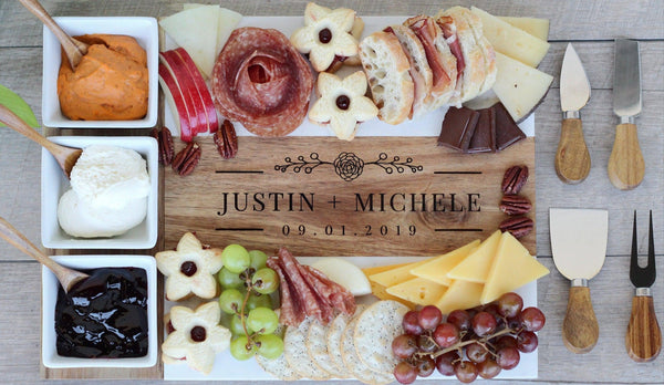Personalized charcuterie board with various foods and cutlery on a wooden surface.