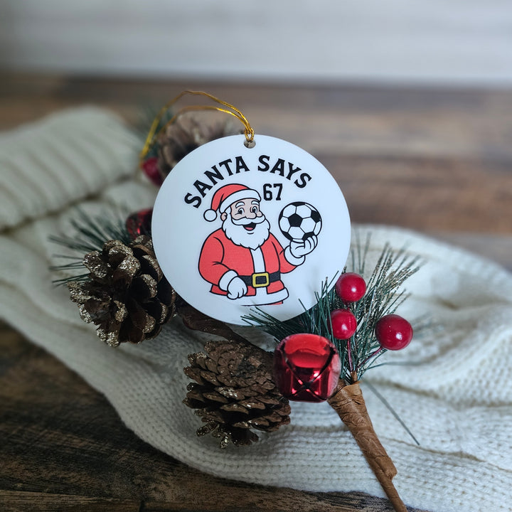Christmas ornament with Santa Claus holding a soccer ball on a decorative background