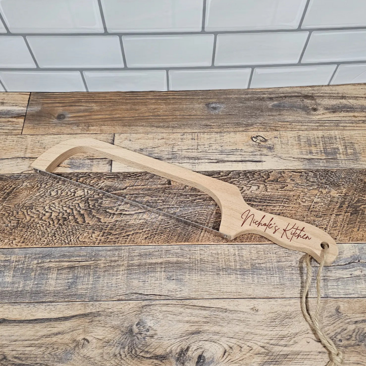 Wooden knife with 'Nicholes Kitchen' engraving on a wooden surface.