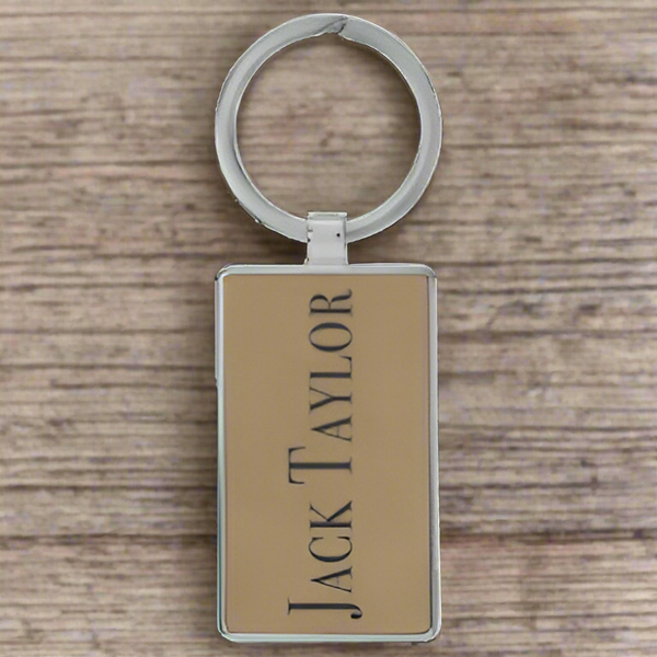 Keychain with 'Jack Taylor' branding on a beige background