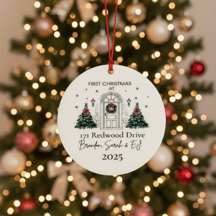 Round Christmas ornament with festive design and text in front of christmas tree
